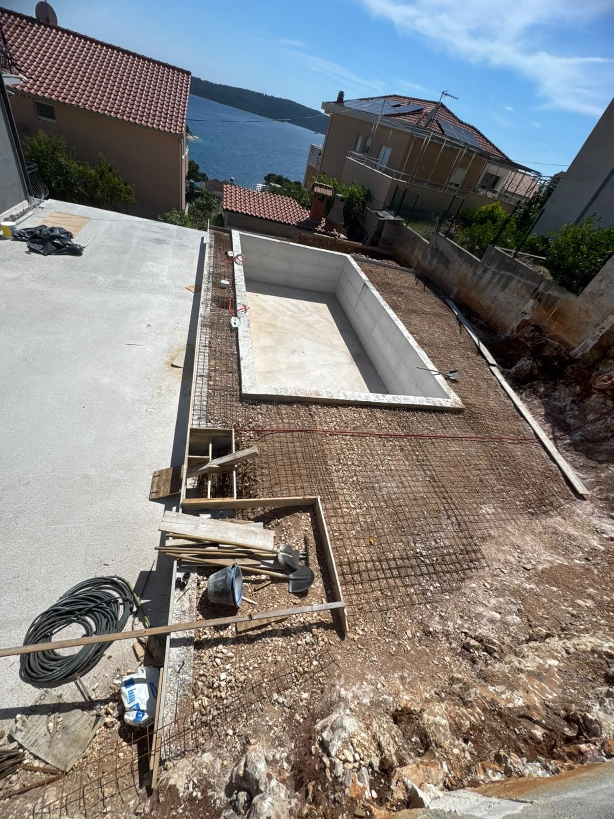 Obiteljska vila Čiovo — pool and terrace under construction, sea beyond